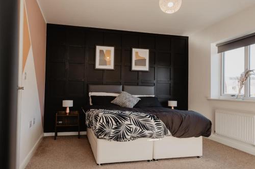 a bedroom with a black headboard and a bed at Central, Large 4 double bedroom house in Leicester