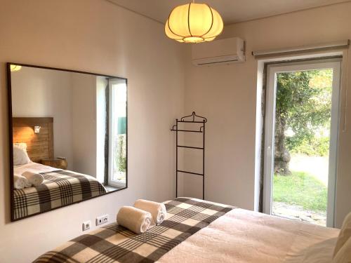 - une chambre avec un lit et un grand miroir dans l'établissement Ar da Beira - Serra da Estrela, à Belmonte