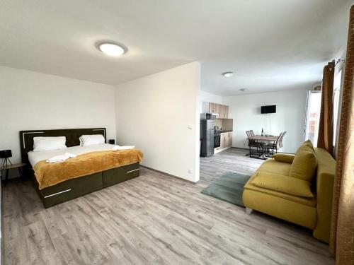 sypialnia z łóżkiem i kanapą oraz salon w obiekcie Sky Apartments 512 w Pilznie