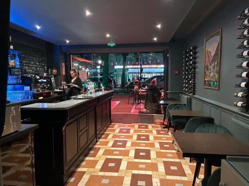 a bar with a woman sitting at a counter at HOTEL & SPA GASQUET in Luchon