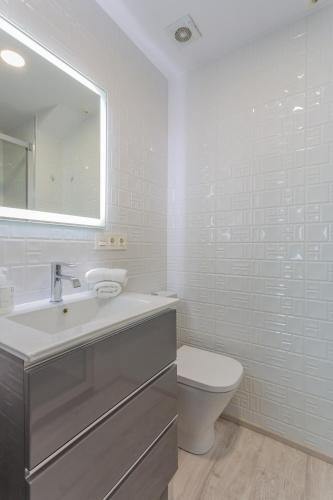 a white bathroom with a sink and a toilet at Center Templo Garden parking gratis in Granada