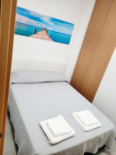 a bed in a room with two towels on it at Penedo Grande suítes t1 in São Bartolomeu de Messines