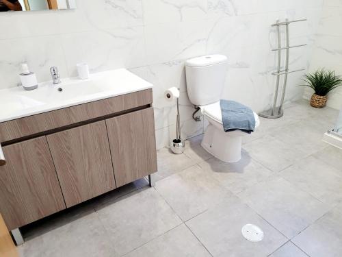 biała łazienka z toaletą i umywalką w obiekcie Penedo Grande suítes t1 w mieście São Bartolomeu de Messines