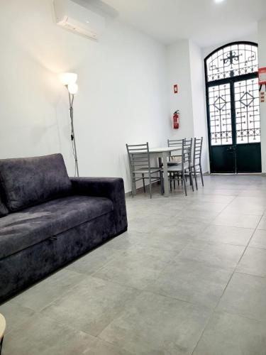 a living room with a couch and a table with chairs at Penedo Grande suítes t1 in São Bartolomeu de Messines