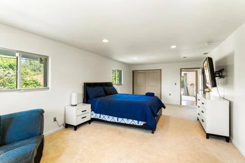 a bedroom with a blue bed and a couch at Luxury Executive Home in Redlands