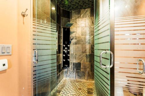 a bathroom with a shower with a glass door at Luxury Executive Home in Redlands