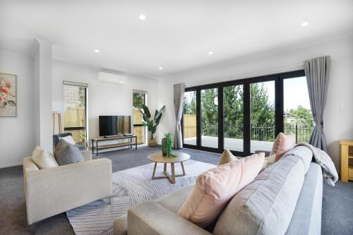 a living room with a couch and a tv at Experience The Magic of Riverside Living - 5 beds in Hamilton