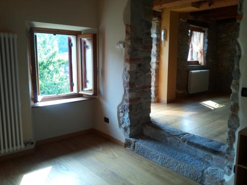 an empty room with a stone wall and a window at Casa Cesira in Tarzo