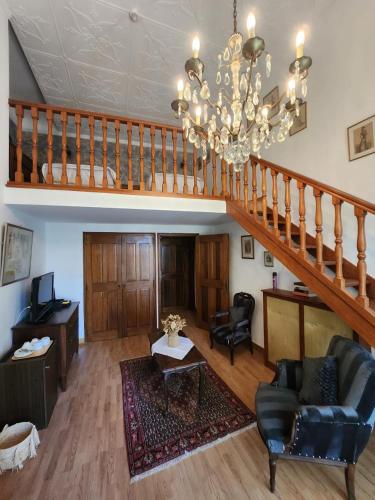 een woonkamer met een trap en een kroonluchter bij Hôtel La fuste in Valensole