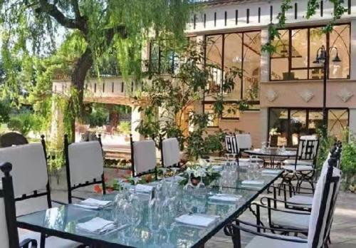 a long table with chairs and glasses on it at Hôtel La fuste in Valensole