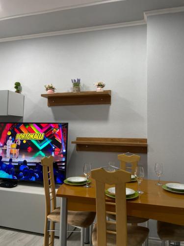 Stone City Apartament في غيروكاستر: غرفة طعام مع طاولة وتلفزيون