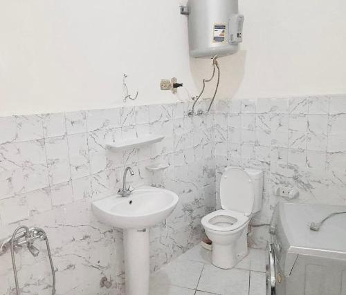 a white bathroom with a toilet and a sink at Central private room in downtown kasr nile in Cairo