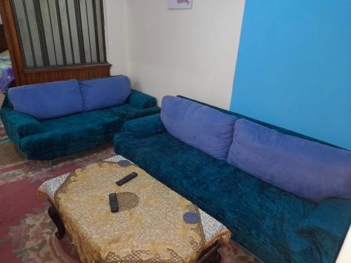 a living room with a blue couch and a table at Central private room in downtown kasr nile in Cairo