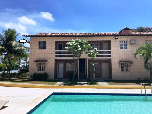 una casa con piscina frente a ella en Casa Tina en Jaguaribe