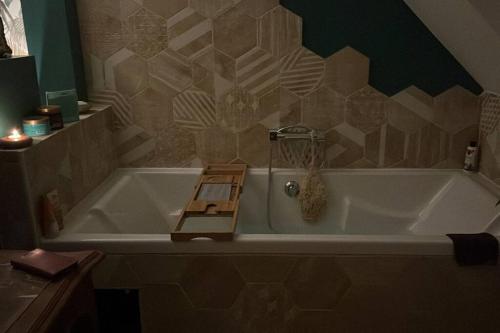 La salle de bains est pourvue d'une baignoire avec une échelle en bois. dans l'établissement Chez Karine et Fred, à Airion
