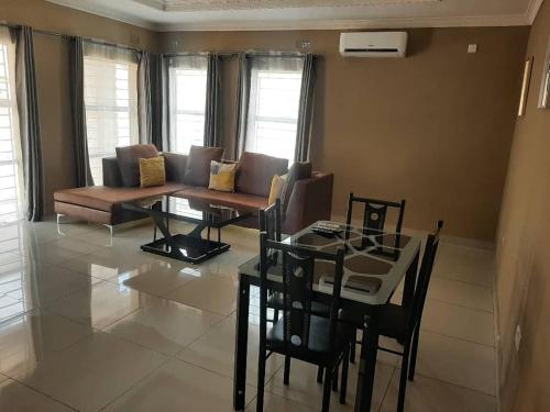 GOLDLAND APARTMENTS في Kitwe: غرفة معيشة مع أريكة وطاولة