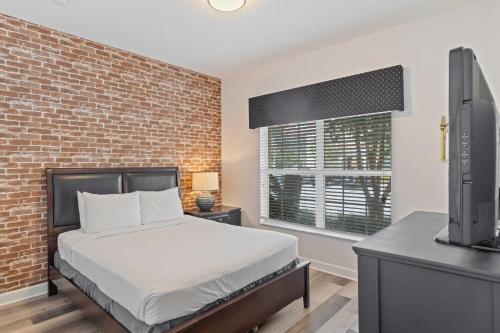a bedroom with a bed and a brick wall at 8960 Cat Palm Road in Kissimmee