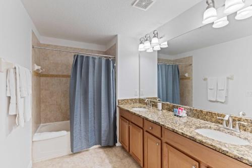 a bathroom with two sinks and a shower at 8960 Cat Palm Road in Kissimmee