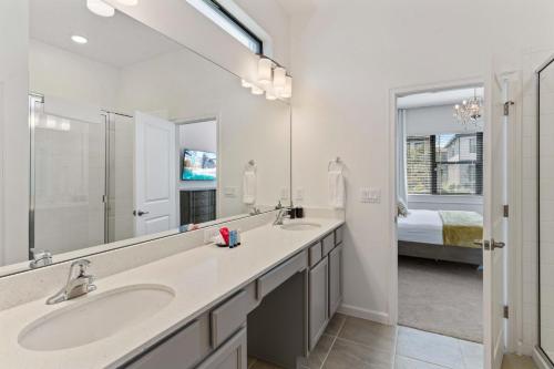 La salle de bains est pourvue de 2 lavabos et d'un grand miroir. dans l'établissement 6103 High Seas Drive, à Orlando