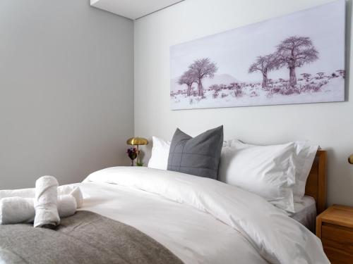 sypialnia z łóżkiem z białą pościelą i drzewami w obiekcie Luxurious Executive Apartment, Ellipse, Waterfall, Midrand w mieście Midrand