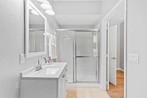 uma casa de banho branca com um chuveiro e um lavatório. em 5063 Tideview Circle 66 em Orlando