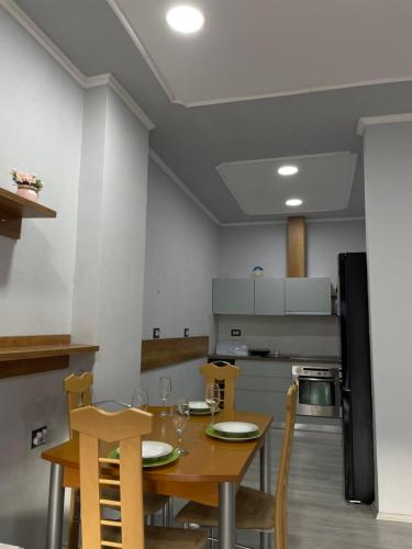 cocina con mesa de madera y sillas en una habitación en Stone City Apartament en Gjirokastër