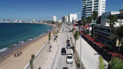 a beach with cars driving down a street and the ocean at Malecón Casa Grande Económica Gran Ubicación in Mazatlán