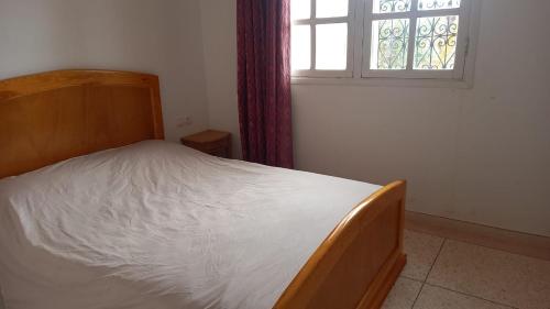 a bed in a room with a window and a bed sidx sidx sidx at Riad Al Afrah in Id Chahadene