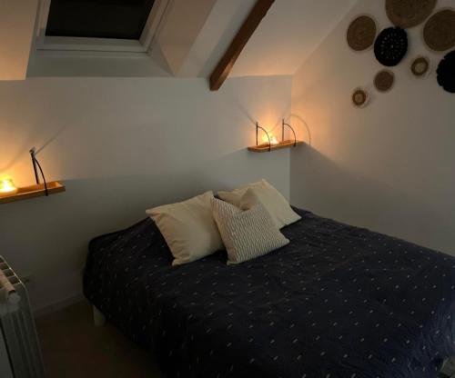 - une chambre avec un lit et deux lampes murales dans l'établissement L'Atypique, 