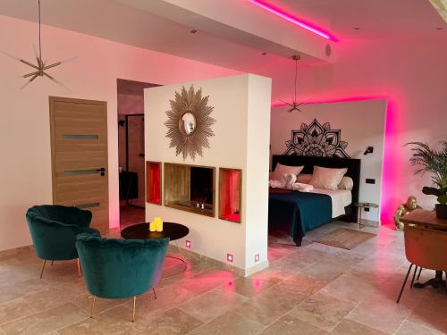 sypialnia z łóżkiem, stołem i krzesłami w obiekcie Le Vertu’Ose w mieście Rougiers