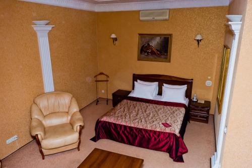 Habitación de hotel con cama y silla en Bogemia Private Residence, en Saratov