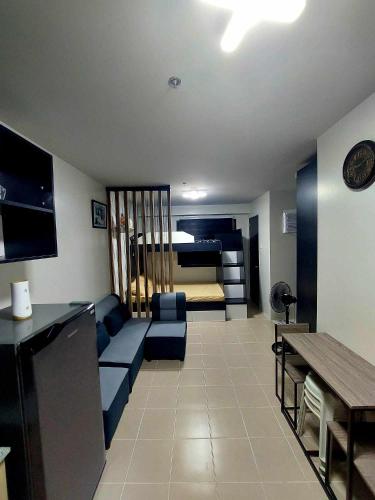 ein Wohnzimmer mit einem blauen Sofa und einem Bett in der Unterkunft Plumera Homes in Lapu Lapu City
