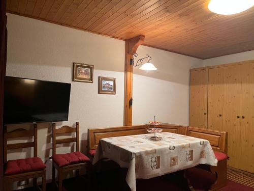 een eetkamer met een tafel en stoelen en een televisie bij Soldanella Cervinia apartment Vda Vacanze in Vetta CIR 0253 in Breuil-Cervinia