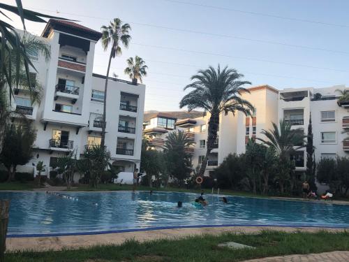 a group of people in a swimming pool in front of buildings at Marina Agadir Sunny Holiday in Agadir