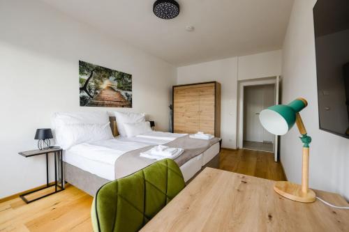 a bedroom with a large bed and a green chair at TAMLiving Center Luxury 4 rooms Smart TV Kitchen Great View in Graz