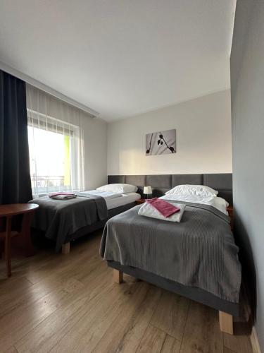 1 dormitorio con 2 camas y ventana en Zielony Dom, en Bolesławiec