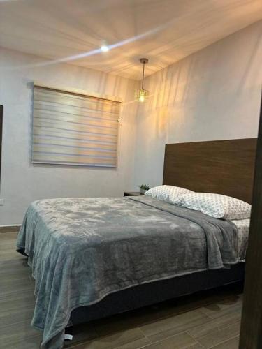 a bedroom with a bed in a room with a window at Depa Danzante in Loreto