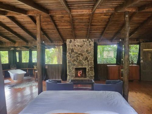 pokój z kominkiem i łóżkiem oraz pokój z wanną w obiekcie Cozy cabin with fireplace w San José