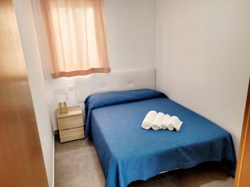 a bedroom with a bed with two white slippers on it at Penedo Grande suítes T2 in São Bartolomeu de Messines