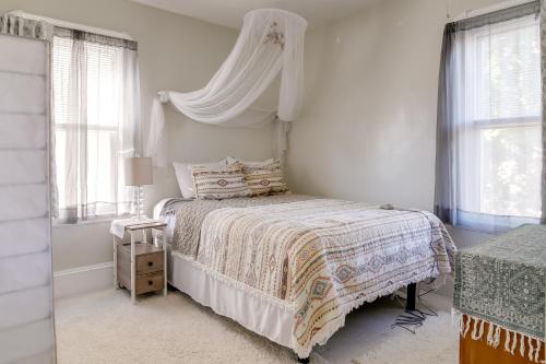 a white bedroom with a bed with a canopy at New Bedford Apartment about 4 Mi to Fort Phoenix Beach in New Bedford