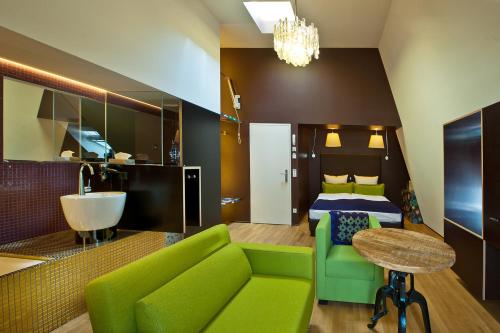 a hotel room with a green couch and a bed at Nala Individuellhotel in Innsbruck