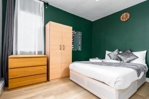 una camera da letto con pareti verdi, un letto e una finestra di City Gate Guest House a Londra