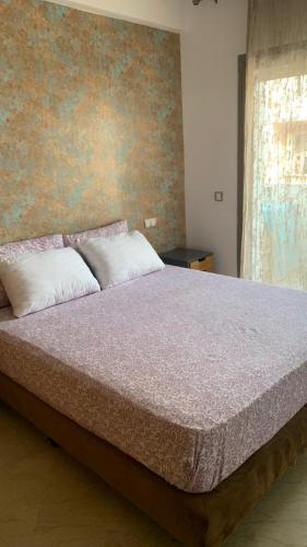 a bedroom with a large bed with two pillows at Appartement propre et calme in Casablanca