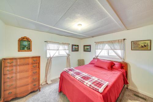 a bedroom with a bed and a dresser and windows at Charming Cottage in Libby with Yard Pets Welcome! in Libby