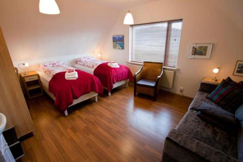 uma sala de estar com duas camas e um sofá em Minna-Mosfell Guesthouse em Mosfellsbaer