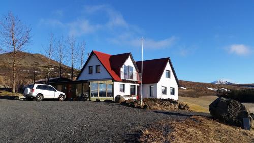 una casa con un coche aparcado delante de ella en Minna-Mosfell Guesthouse, en Mosfellsbær