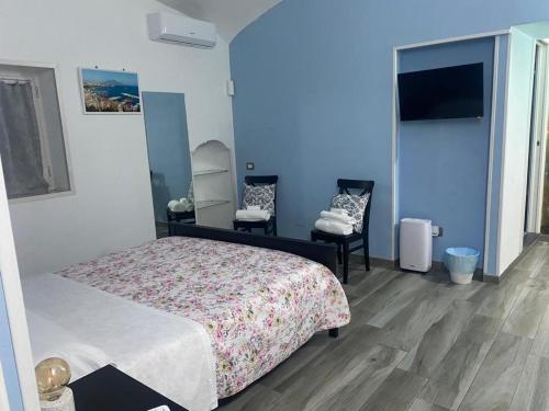 ein Schlafzimmer mit einem Bett und zwei Stühlen darin in der Unterkunft Casa Sania in Neapel