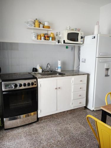 eine Küche mit einem Herd und einem Kühlschrank in der Unterkunft Una casita en la loma in La Plata