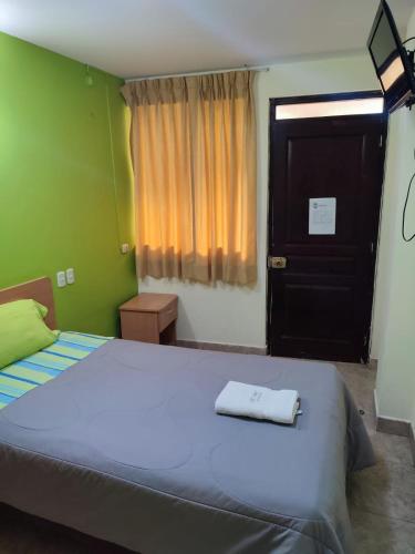a bedroom with a large bed and a black door at Hotel Misky Samay in Ayacucho
