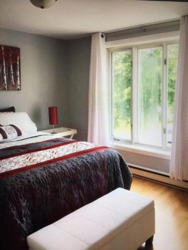 a bedroom with a bed and a window at Le 10620 beau, grand et charmant 5 et demi in Quebec City